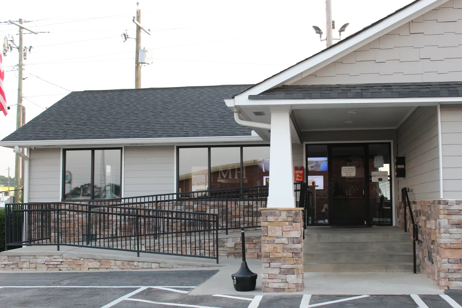 The front of the staffed office at The Storage Key on Highway 411 in Cartersville, with a stone-veneer entry column, wheelchair ramp, and American flag.