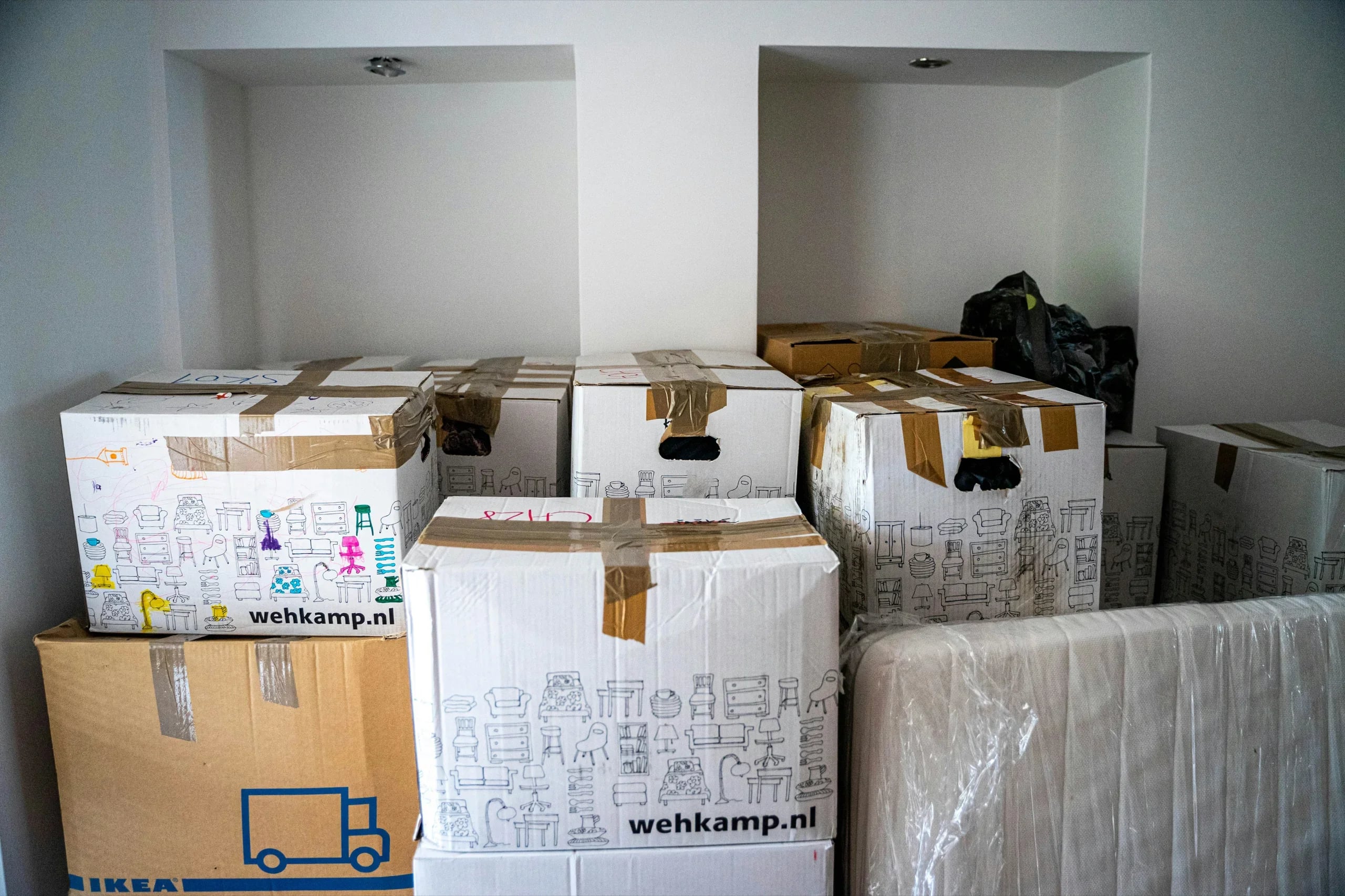 Cardboard moving boxes stacked together, packed and taped, ready to load.